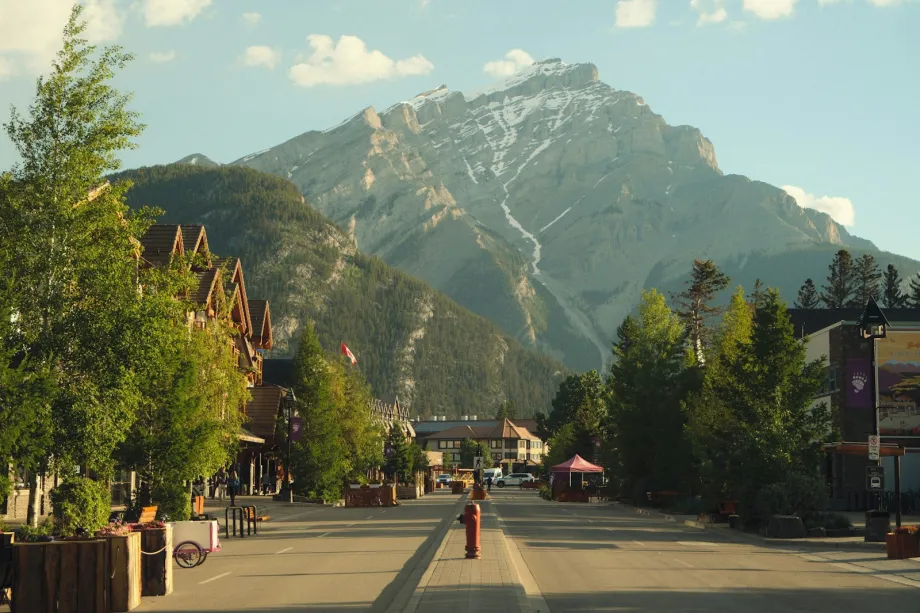 Street lined with shops leading toward a large mountain in Banff